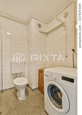 a laundry room with a washer and dryer in the corner, while it's not too clean 107895309