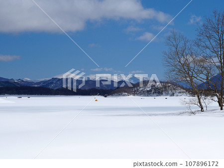 Frozen Lake Hibara in Fukushima Prefecture. The collaboration between the vast white snowfield and the snowy mountains is impressive and beautiful. Frozen Lake Hibara in Fukushima Prefecture. The collaboration between the vast white snowfield and the snowy mountains is impressive and beautiful. 107896172