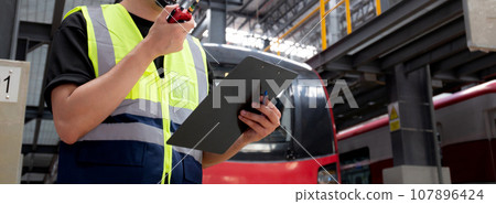 Young caucasian engineer man or worker hold clipboard for looking and checking electric train. 107896424