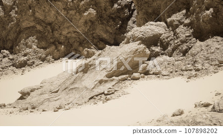 A group of rocks on a sandy beach A group of rocks on a sandy beach 107898202