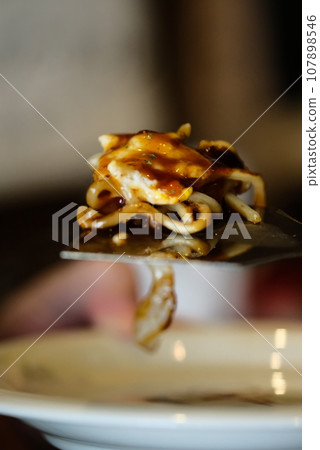 Okonomiyaki eaten with a spatula 107898546