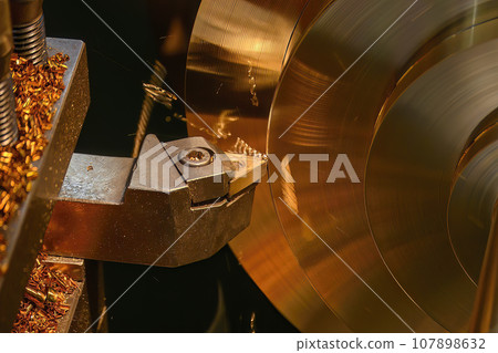 Closeup scene the lathe machine finish cut the brass parts by lathe tools. Closeup scene the lathe machine finish cut the brass parts by lathe tools. 107898632