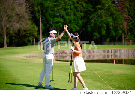 A couple in their 40s enjoying golf A couple in their 40s enjoying golf 107899384