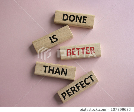 Done is better than Perfect symbol. Wooden blocks with words Done is better than Perfect. Beautiful pink background. Business concept. Copy space. 107899683