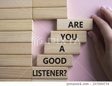 Listening skills symbol. Wooden blocks with words Are you a good Listener. Beautiful pink background. Businessman hand. Business and Are you a good Listener concept. Copy space. 107899734