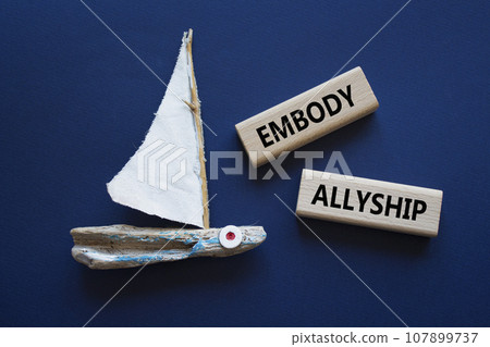 Embody Allyship symbol. Concept word Embody Allyship on wooden blocks. Beautiful deep blue background with boat. Business and Embody Allyship concept. Copy space 107899737