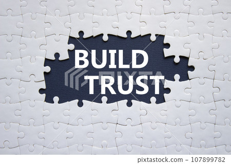 Build trust symbol. White puzzle with words Build trust. Beautiful dark blue background. Business and Build trust concept. Copy space. Build trust symbol. White puzzle with words Build trust. Beautiful dark blue background. Business and Build trust concept. Copy space. 107899782