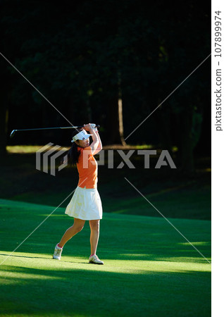 A woman in her 40s enjoying golf A woman in her 40s enjoying golf 107899974