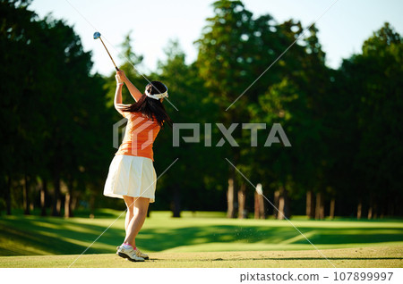 A woman in her 40s enjoying golf 107899997