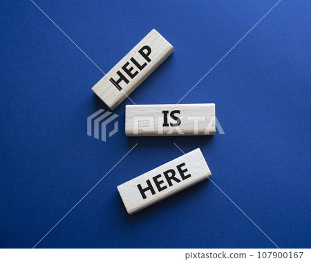 Help is here symbol. Wooden blocks with words Help is here. Beautiful deep blue background. Business and Help is here concept. Copy space. 107900167