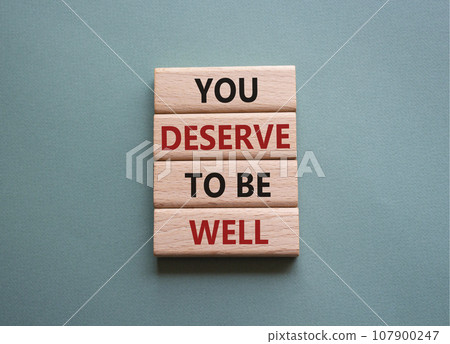 You deserve to be well symbol. Wooden blocks with words You deserve to be well. Beautiful grey green background. You deserve to be well concept. Copy space. 107900247