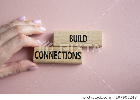 Build Connections symbol. Concept word Build Connections on wooden blocks. Businessman hand. Beautiful pink background. Business and Build Connections concept. Copy space 107900248