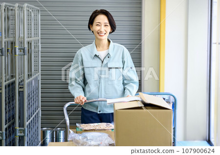 穿著工作服的女工在倉庫盤點 穿著工作服的女工在倉庫盤點 107900624