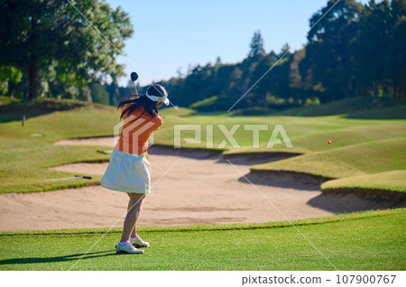 A woman in her 40s enjoying golf A woman in her 40s enjoying golf 107900767