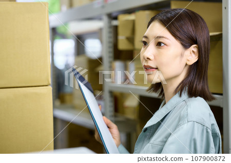 女工在盤點時檢查庫存 女工在盤點時檢查庫存 107900872