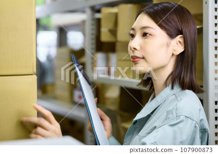 女工在盤點時檢查庫存 女工在盤點時檢查庫存 107900873