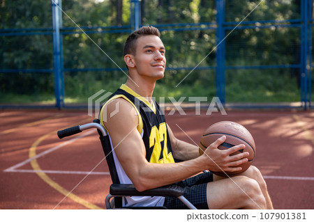 Man with a disability exercising and has workout at basketball court. 107901381
