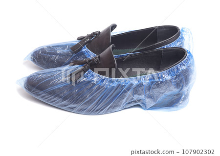black men's leather shoes in shoe covers isolated on white background. black men's leather shoes in shoe covers isolated on white background. 107902302