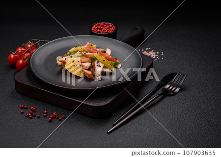Delicious fresh juicy salad of sliced chicken, grapefruit, lettuce, sesame with olive oil 107903635