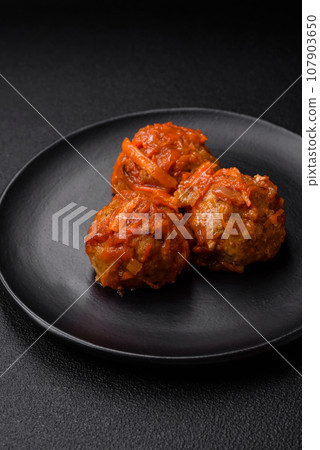 Delicious fresh meatballs from minced meat or fish with tomato sauce 107903650