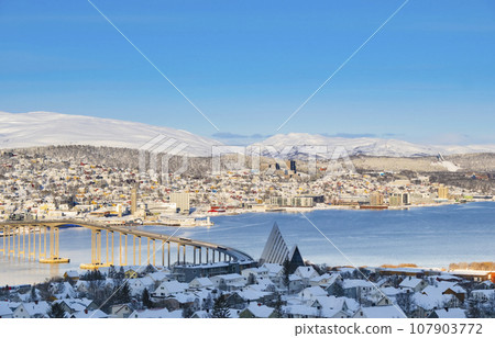 Snowy roofs, embankment near the port and fishing ships, Sunny winter day. Snowy roofs, embankment near the port and fishing ships, Sunny winter day. 107903772