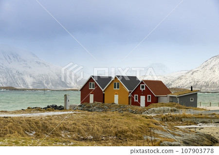 Winter Norway landscape with rorbu on the ocean beach and snow Winter Norway landscape with rorbu on the ocean beach and snow 107903778