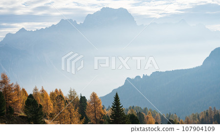Colorful autumn alpine landscape with hazy mountains and golden larches, Italy, Europe Colorful autumn alpine landscape with hazy mountains and golden larches, Italy, Europe 107904109