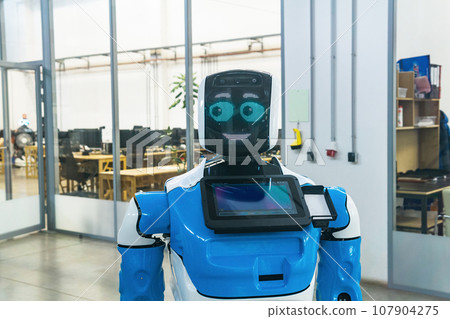 humanoid robot with a friendly face in the interior of a modern office humanoid robot with a friendly face in the interior of a modern office 107904275