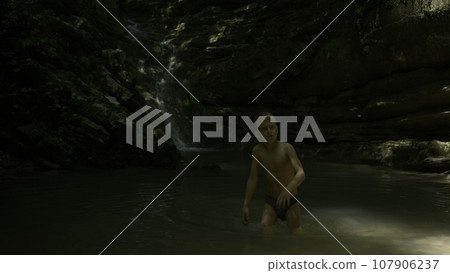 Boy kid having a great time in the cold mountain stream. Creative. Beautiful waterfall and big cliffs. Boy kid having a great time in the cold mountain stream. Creative. Beautiful waterfall and big cliffs. 107906237