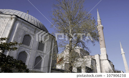 Low angle view of a white mosque with minarets. Action. Concept of religion and architecture. Low angle view of a white mosque with minarets. Action. Concept of religion and architecture. 107906238