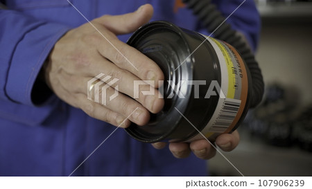 Close up of fireman holding professional filter of labor protection. Clip. Detail of emergency workers routine. 107906239