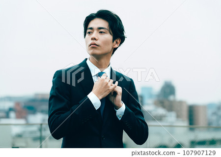 年輕商人在城裡調整領帶 107907129