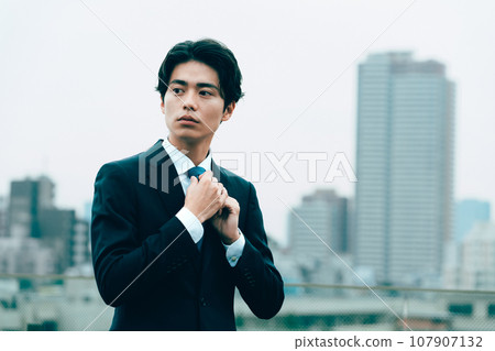 年輕商人在城裡調整領帶 107907132