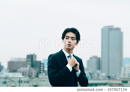 年輕商人在城裡調整領帶 107907134