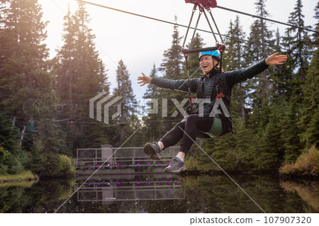 Adventure Woman riding on a Zipline. 107907320