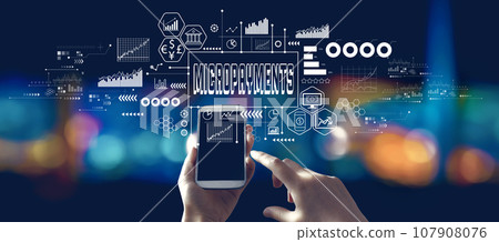 Micropayments theme with person using a smartphone at night 107908076