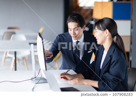 商務人士一邊看電腦一邊說話 107908283