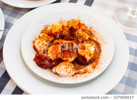 Galician boiled octopus with smoked paprika and potato slices Galician boiled octopus with smoked paprika and potato slices 107908837