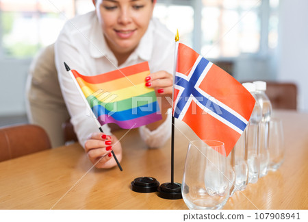 Unrecognizable girl sets midget Norway and Pride flag before international negotiations 107908941
