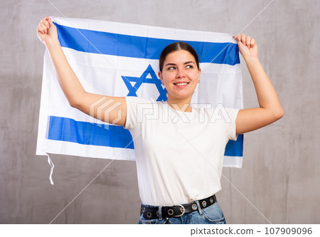 Smiling young woman holding Israel flag Smiling young woman holding Israel flag 107909096