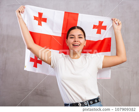 Attractive female football fan holding Georgia flag 107909382