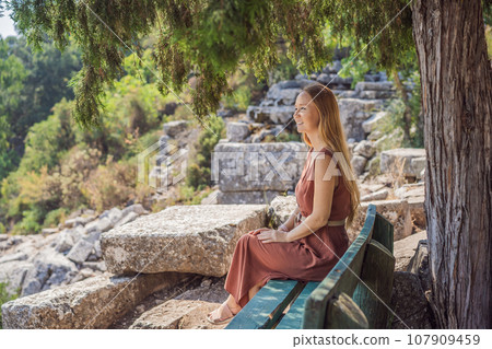 Woman tourist explores Stunning Ancient Theater of Termessos Ancient City turkiye, GO Everywhere 107909459