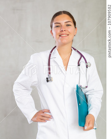 Happy female doctor standing with file in hands Happy female doctor standing with file in hands 107909582