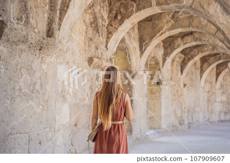 Woman tourist explores Aspendos Ancient City. Aspendos acropolis city ruins, cisterns, aqueducts and old temple. Aspendos Antalya Turkey. turkiye Woman tourist explores Aspendos Ancient City. Aspendos acropolis city ruins, cisterns, aqueducts and old temple. Aspendos Antalya Turkey. turkiye 107909607