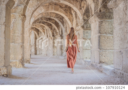 Woman tourist explores Aspendos Ancient City. Aspendos acropolis city ruins, cisterns, aqueducts and old temple. Aspendos Antalya Turkey. turkiye Woman tourist explores Aspendos Ancient City. Aspendos acropolis city ruins, cisterns, aqueducts and old temple. Aspendos Antalya Turkey. turkiye 107910124