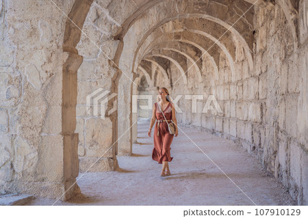 Woman tourist explores Aspendos Ancient City. Aspendos acropolis city ruins, cisterns, aqueducts and old temple. Aspendos Antalya Turkey. turkiye 107910129