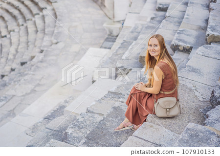 Woman tourist explores Aspendos Ancient City. Aspendos acropolis city ruins, cisterns, aqueducts and old temple. Aspendos Antalya Turkey. turkiye Woman tourist explores Aspendos Ancient City. Aspendos acropolis city ruins, cisterns, aqueducts and old temple. Aspendos Antalya Turkey. turkiye 107910133