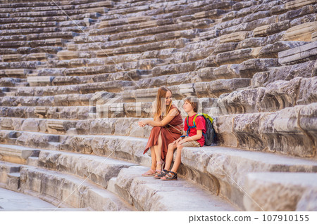 mother and son tourists explores Aspendos Ancient City. Traveling with kids concept. Aspendos acropolis city ruins, cisterns, aqueducts and old temple. Aspendos Antalya Turkey. turkiye mother and son tourists explores Aspendos Ancient City. Traveling with kids concept. Aspendos acropolis city ruins, cisterns, aqueducts and old temple. Aspendos Antalya Turkey. turkiye 107910155
