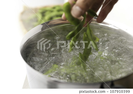 Boil edamame in a pot As an accompaniment to alcohol (snacks for alcohol) Boiled edamame with salt Beans Edamame White background Boi 107910399