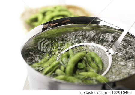 Boil edamame in a pot As an accompaniment to alcohol (snacks for alcohol) Boiled edamame with salt Beans Edamame White background Boi 107910403